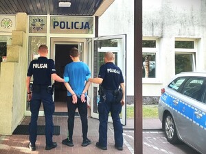 Policjanci doprowadzają zatrzymanego do budynku komisariatu Policji
