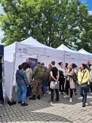 Osoby zainteresowane rozmową z policjantem stoją obok stoiska