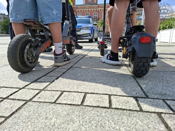Stopa w obuwiu sportowym ułożona na hulajnodze elektrycznej