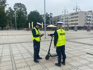 Policjanci rozmawiają z użytkownikiem hulajnogi