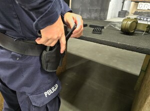 Policjant trzyma rękę przy kaburze