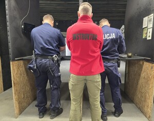 instruktor stoi za policjantami na strzelnicy