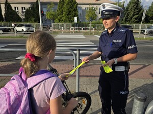 Policjantka wręcza odblask rowerzyście