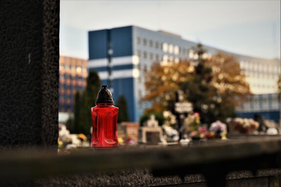 Zdjęcie znicza na tle budynku Komendy Wojewódzkiej Policji w Katowicach